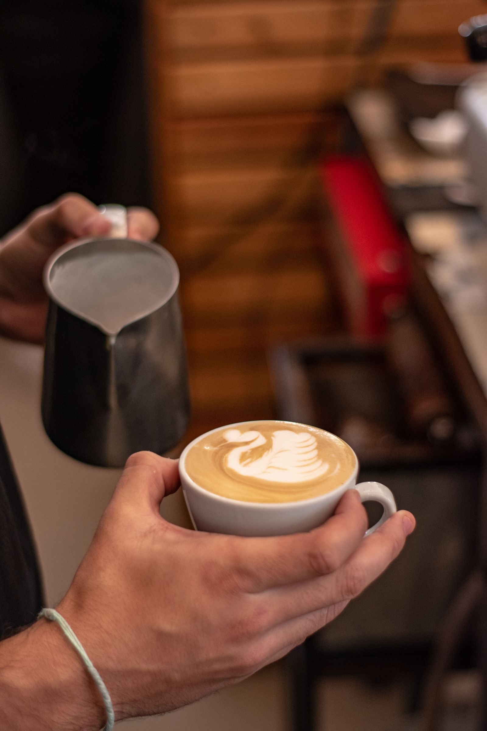 Barista presenting a cup of latte art